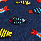 Fish Tank bead close-up on Navy woven jute.