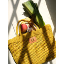 Petite Mercado Tote in Ocre — close view in hard sunlight, packed with leeks, fruit and a striped cloth
