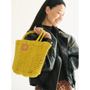 Petite Mercado Tote in Ocre — carried over the shoulder by its handles, styled with a black leather jacket
