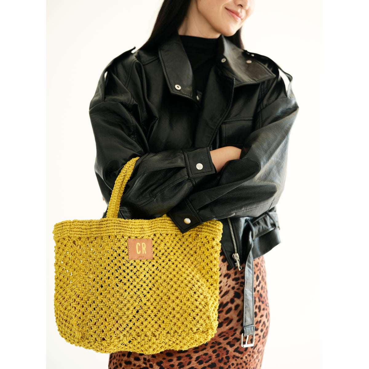 Petite Mercado Tote in Ocre — held in front of the body, styled with a black leather jacket over a leopard-print skirt