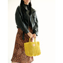 Petite Mercado Tote in Ocre — carried in hand at the side, styled with a black leather jacket and a leopard-print skirt