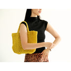 Petite Mercado Tote in Ocre — carried over the shoulder, shown in profile against a plain studio background