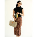 Petite Mercado in Natural — carried at the side by its handles, styled with a black sleeveless knit top and a leopard-print midi skirt